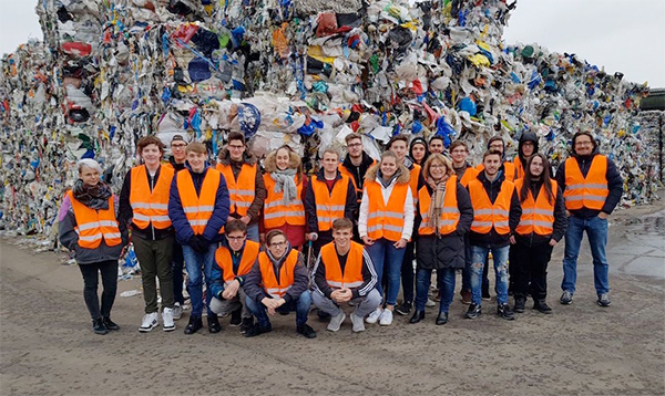 Schüler vor einem Müllberg