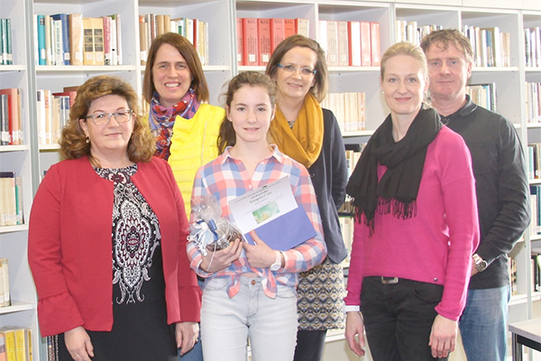Schülerin mit Lehrern in der Schulbibliothek