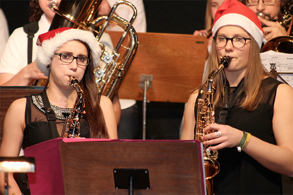 Schülerinnen mit Weihnachtsmützen und Saxophon